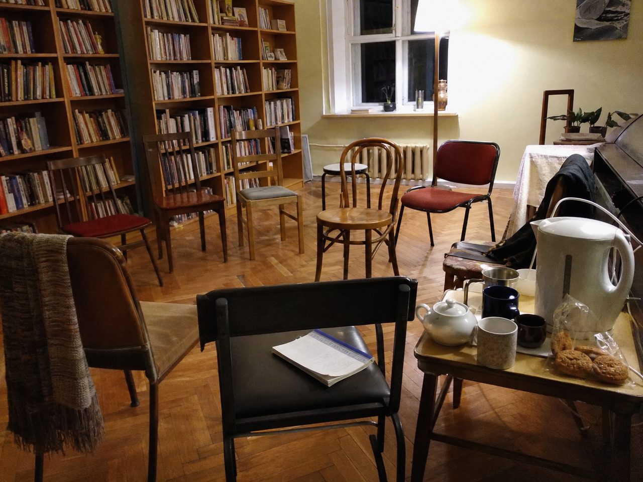 Стулья кругом в читальном зале, книга на одном из них и чайник на столике