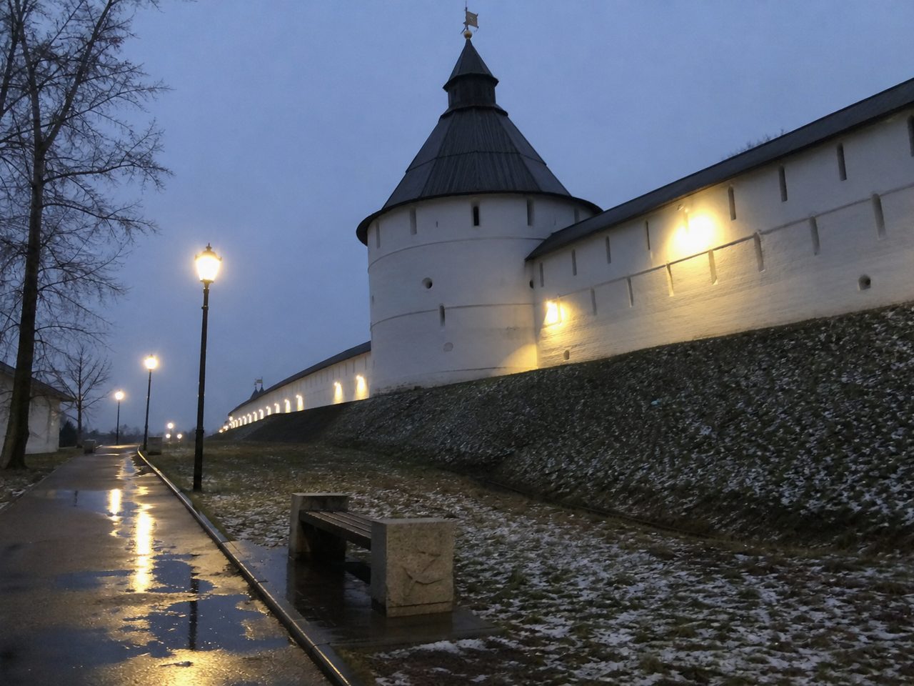 Белые стены и башня кремля в ранних ноябрьских сумерках с включёнными фонарями